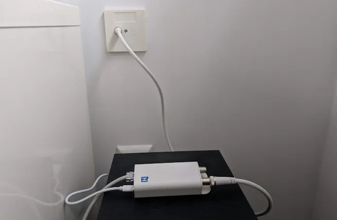 De INCA 1G-adapter is in de woonkamer op de wandcontactdoos aangesloten.