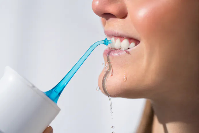 Je tanden schoonmaken met een waterpik.