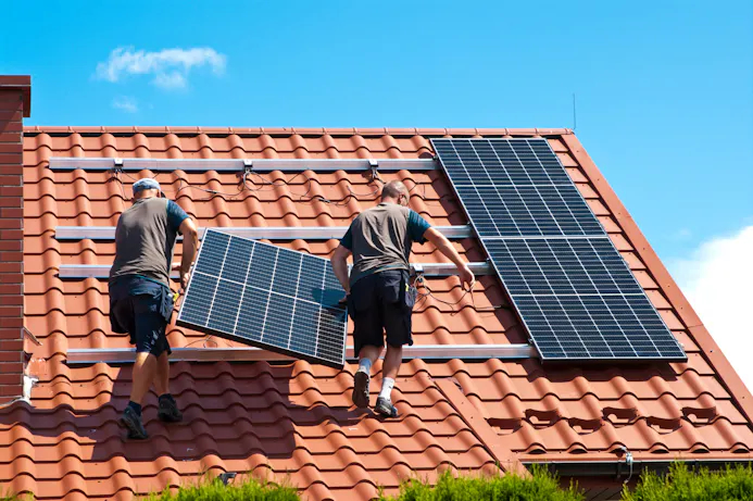 Installateurs installeren zonnepanelen op een dak