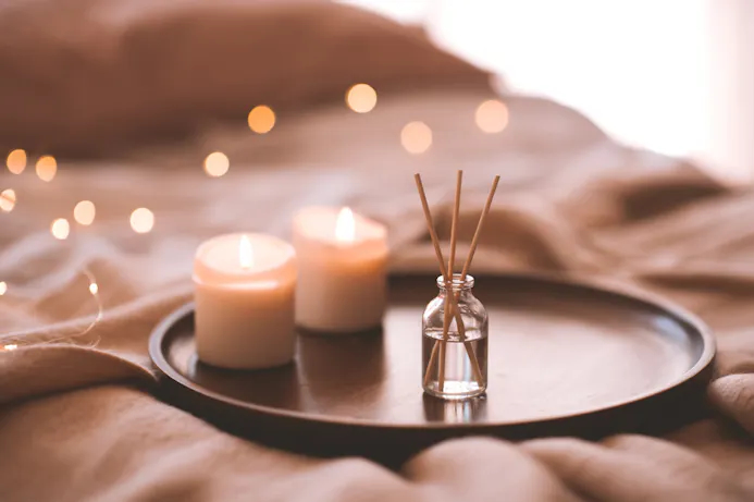 Kaarsen en geurstokjes op dienblad op bed