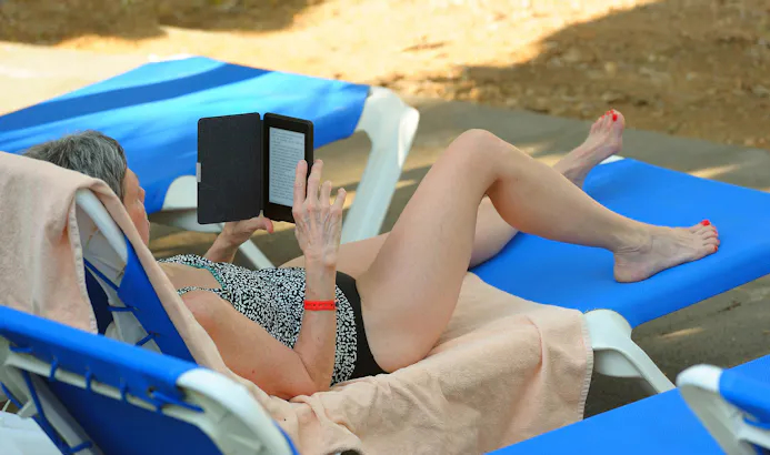 Vrouw leest op het strand op haar e-reader