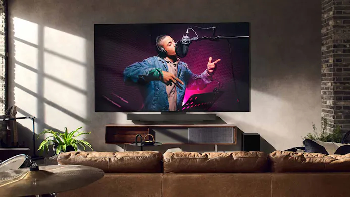 Zanger afgebeeld op grote LG tv in woonkamer.