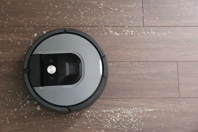 Een robotstofzuiger die rijst opzuigt van een laminaat vloer