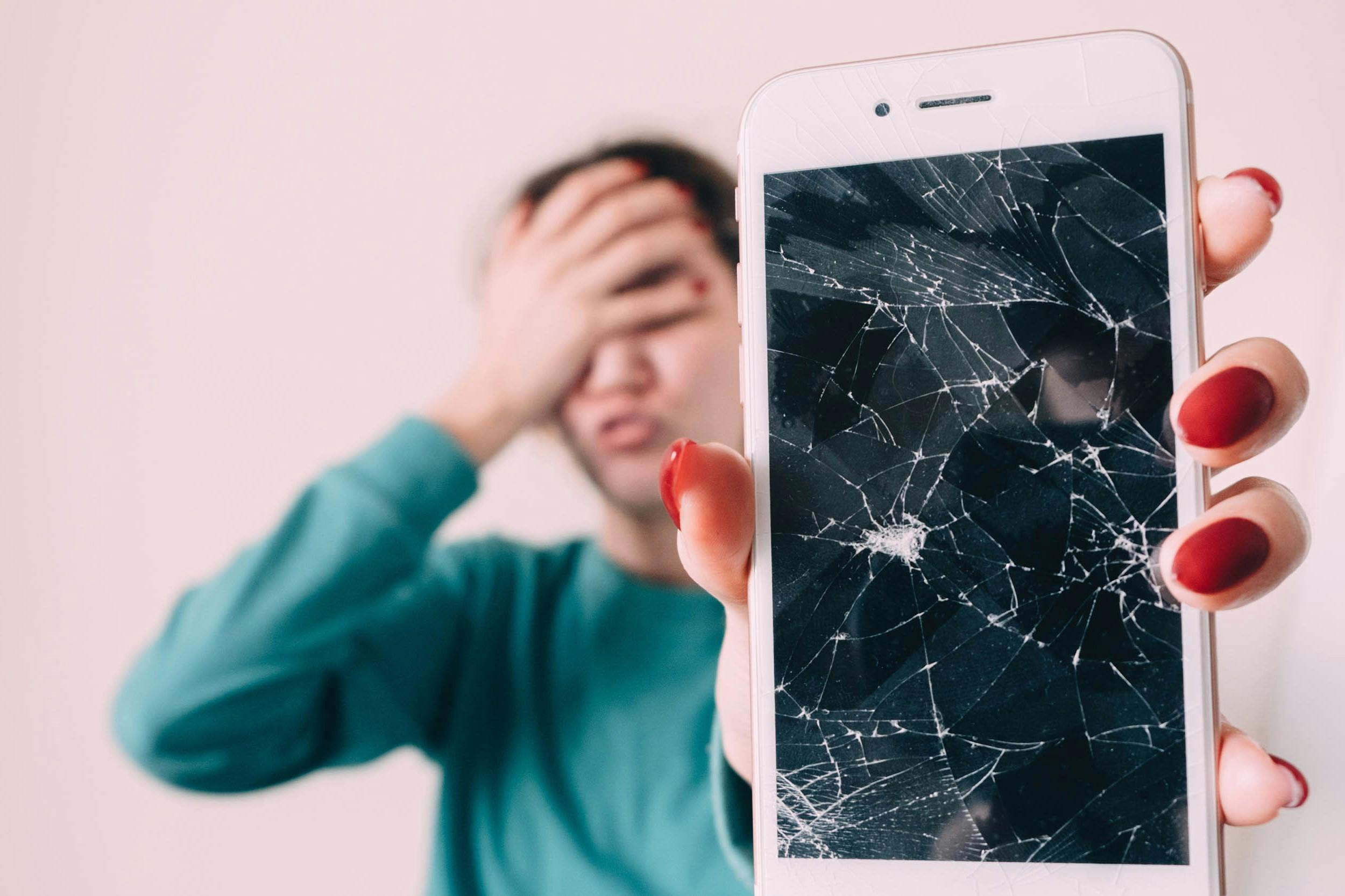 Vrouw met smartphone met gebroken scherm