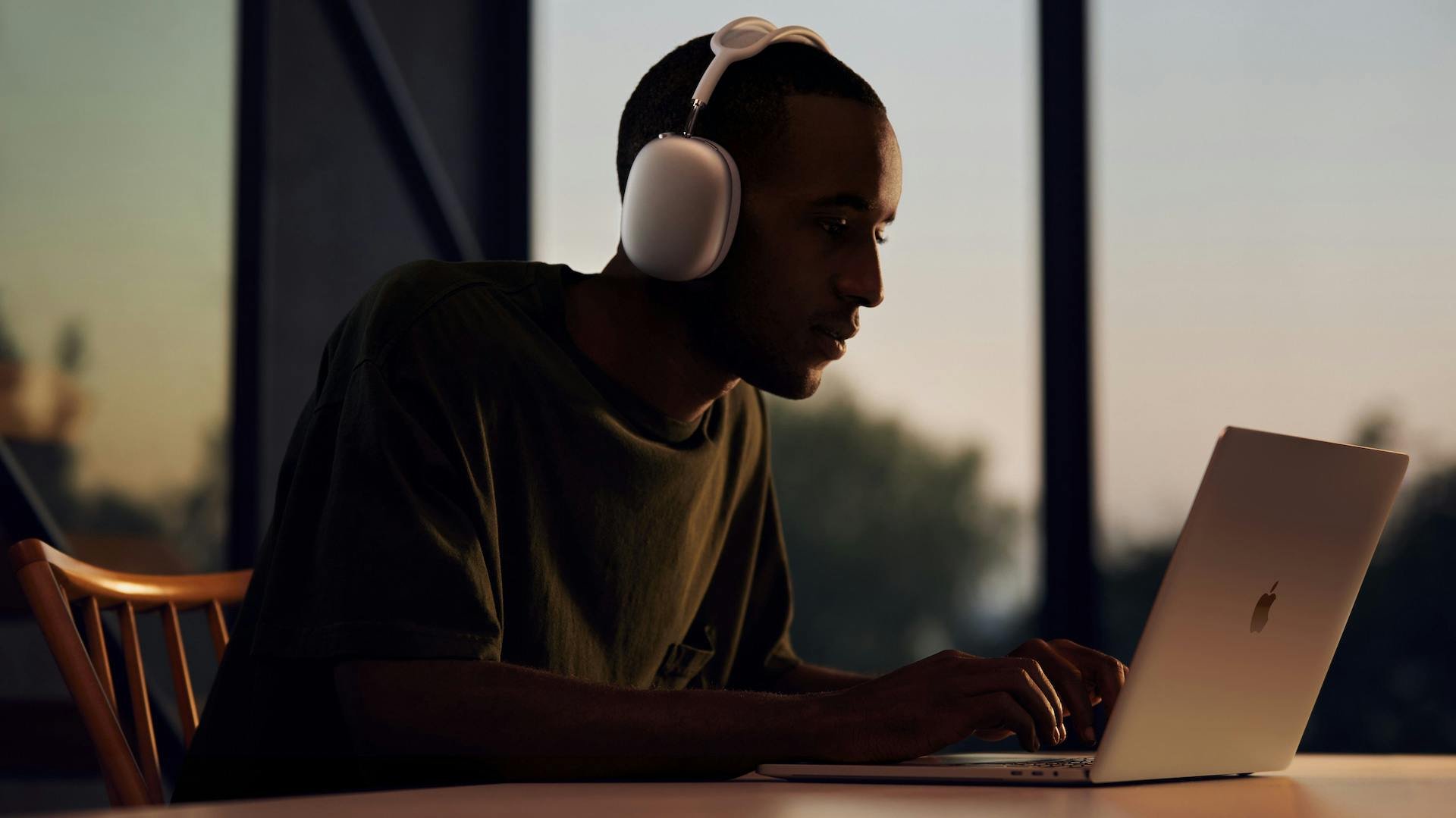Man met AirPods Max aan een laptop