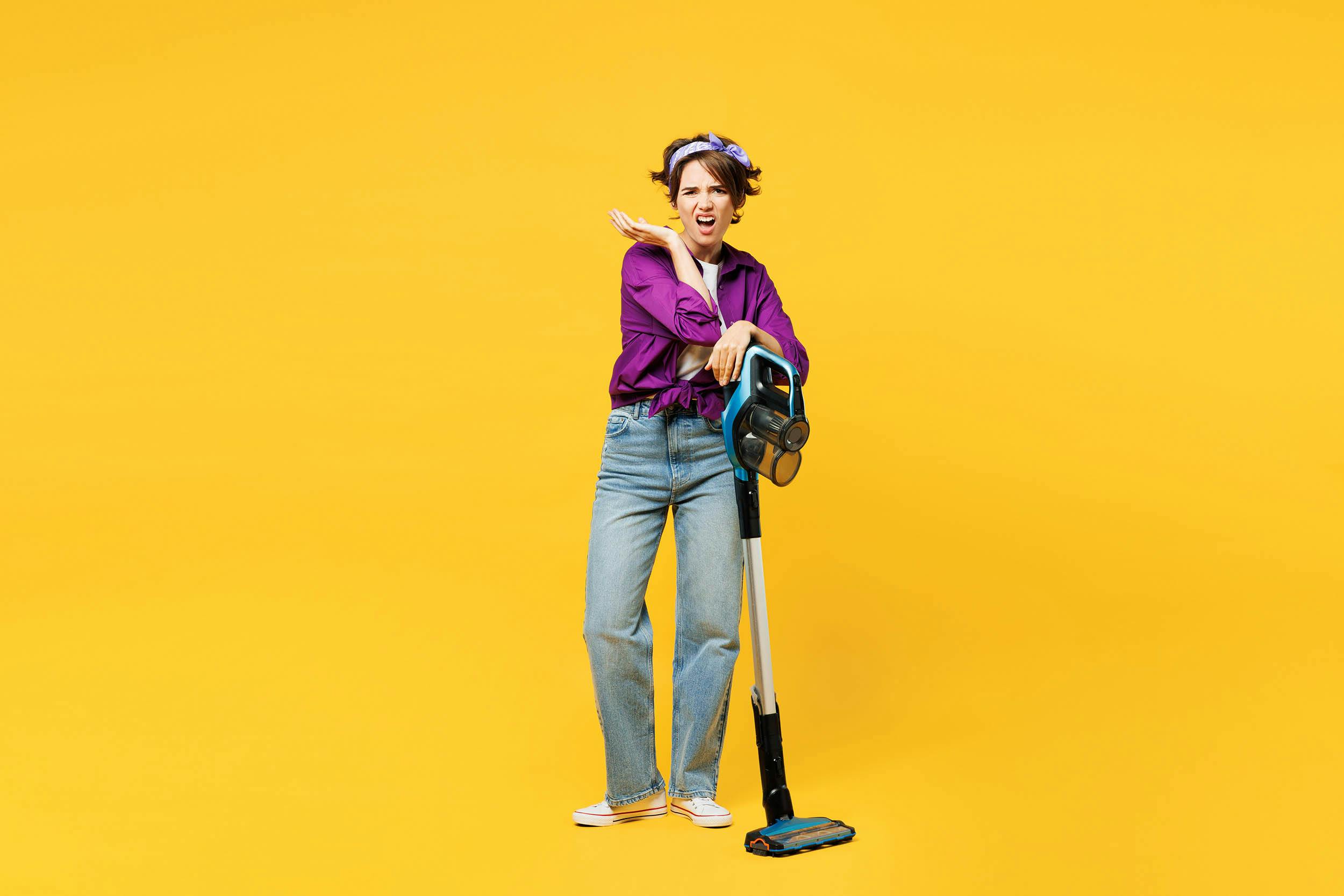 Gefrustreerde vrouw met stofzuiger